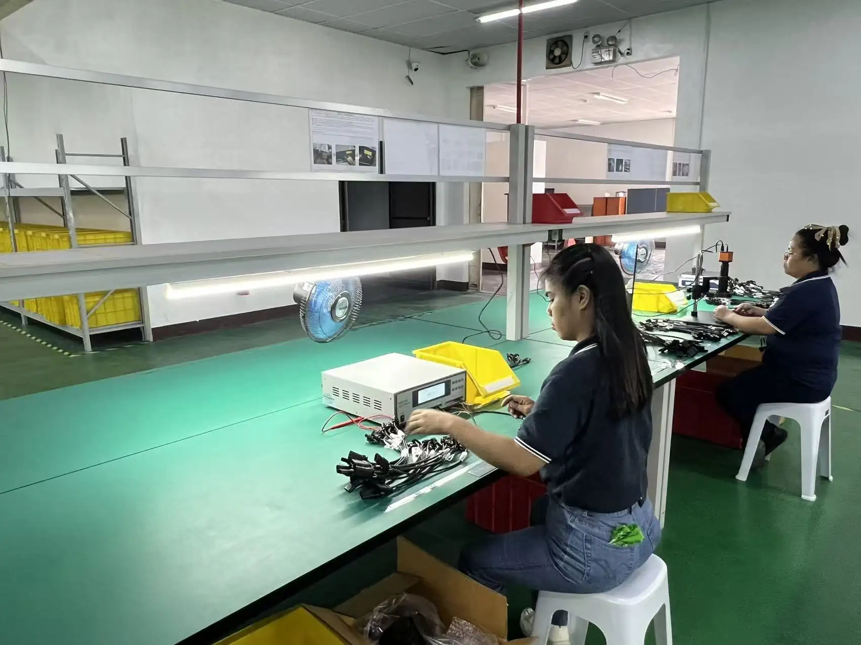Operator running a 100 percent electrical test on finished cable harnesses at the Cavite plant